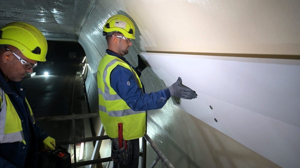 Montage der Brandschutzplatten an die Tunnelwand durch Monteure der Firma Bauschutz.